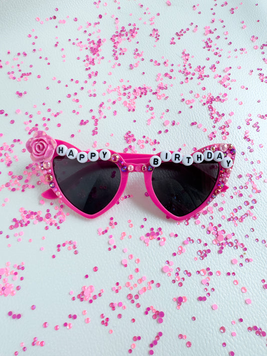 a pair of pink sunglasses with happy birthday written on them