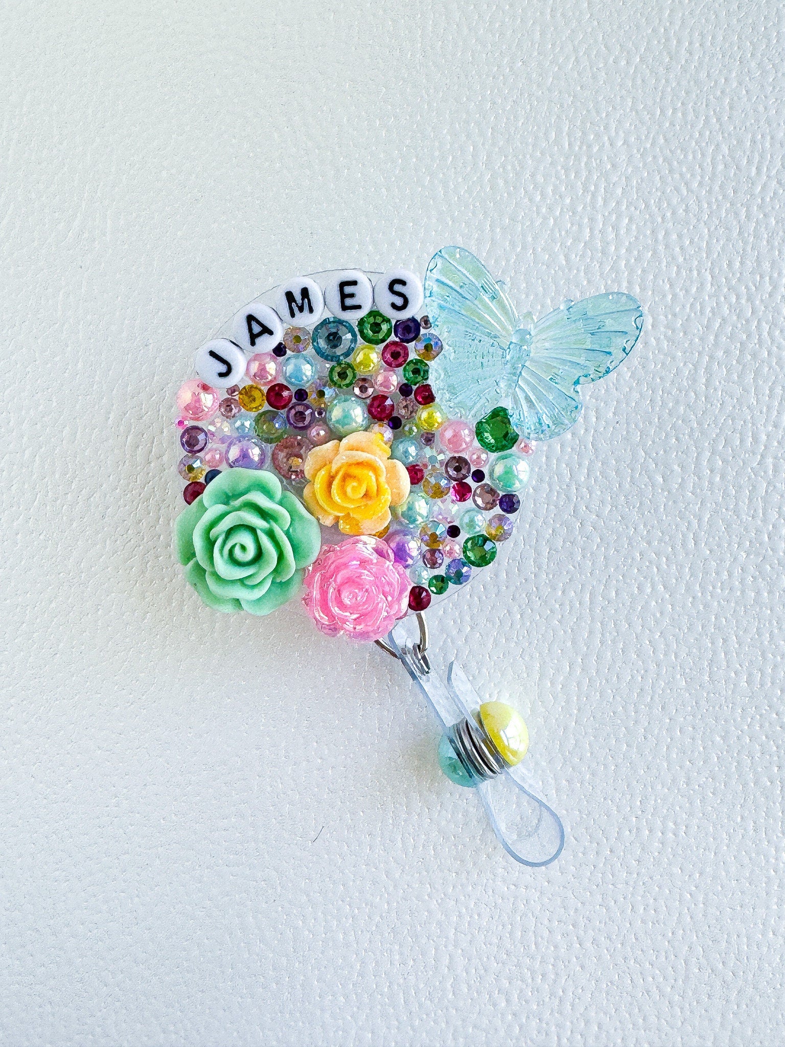 a brooch with flowers and a butterfly on it