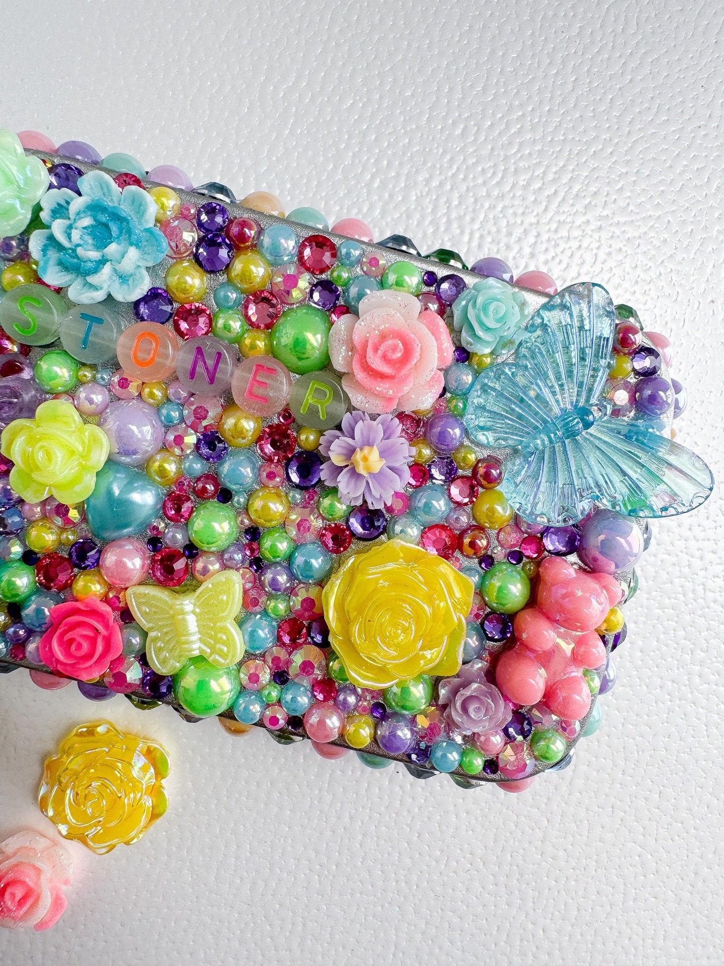 a cell phone covered in colorful beads and flowers