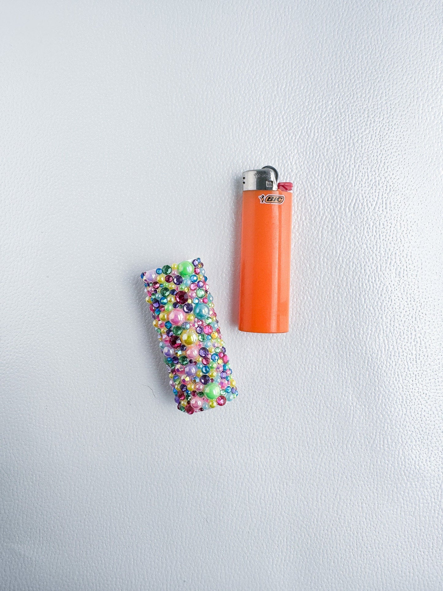 an orange lighter and a lighter with sprinkles on it