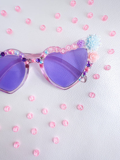 a pair of purple sunglasses with flowers on them