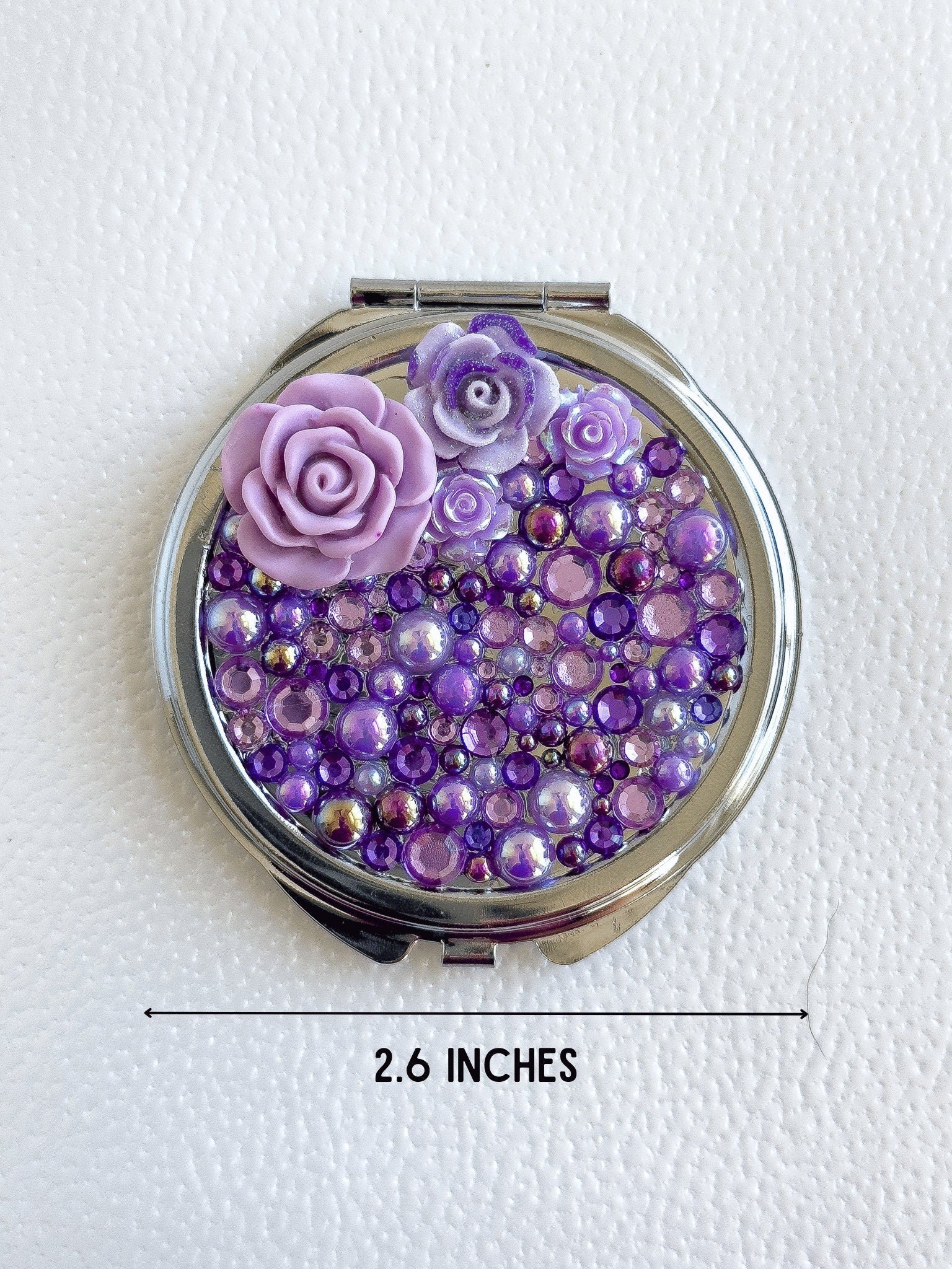 a compact compact case with purple and purple flowers on it