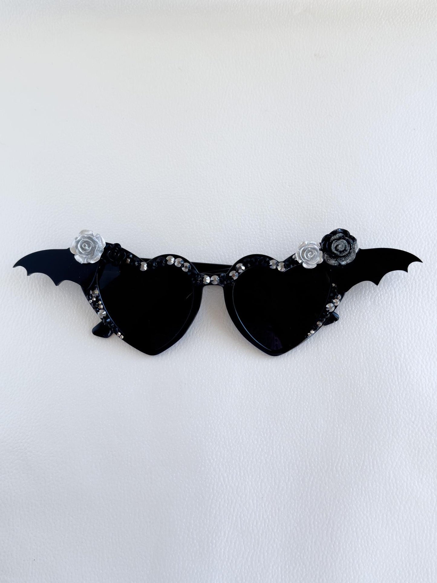 a pair of black sunglasses with bats on them