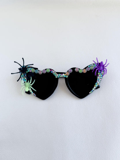 a pair of sunglasses with spider decorations on them