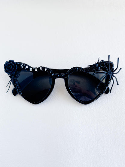 a pair of black sunglasses with a rose on the side